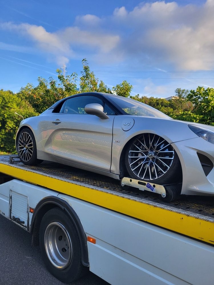 Voiture de sport chargée sur le plateau de la dépanneuse